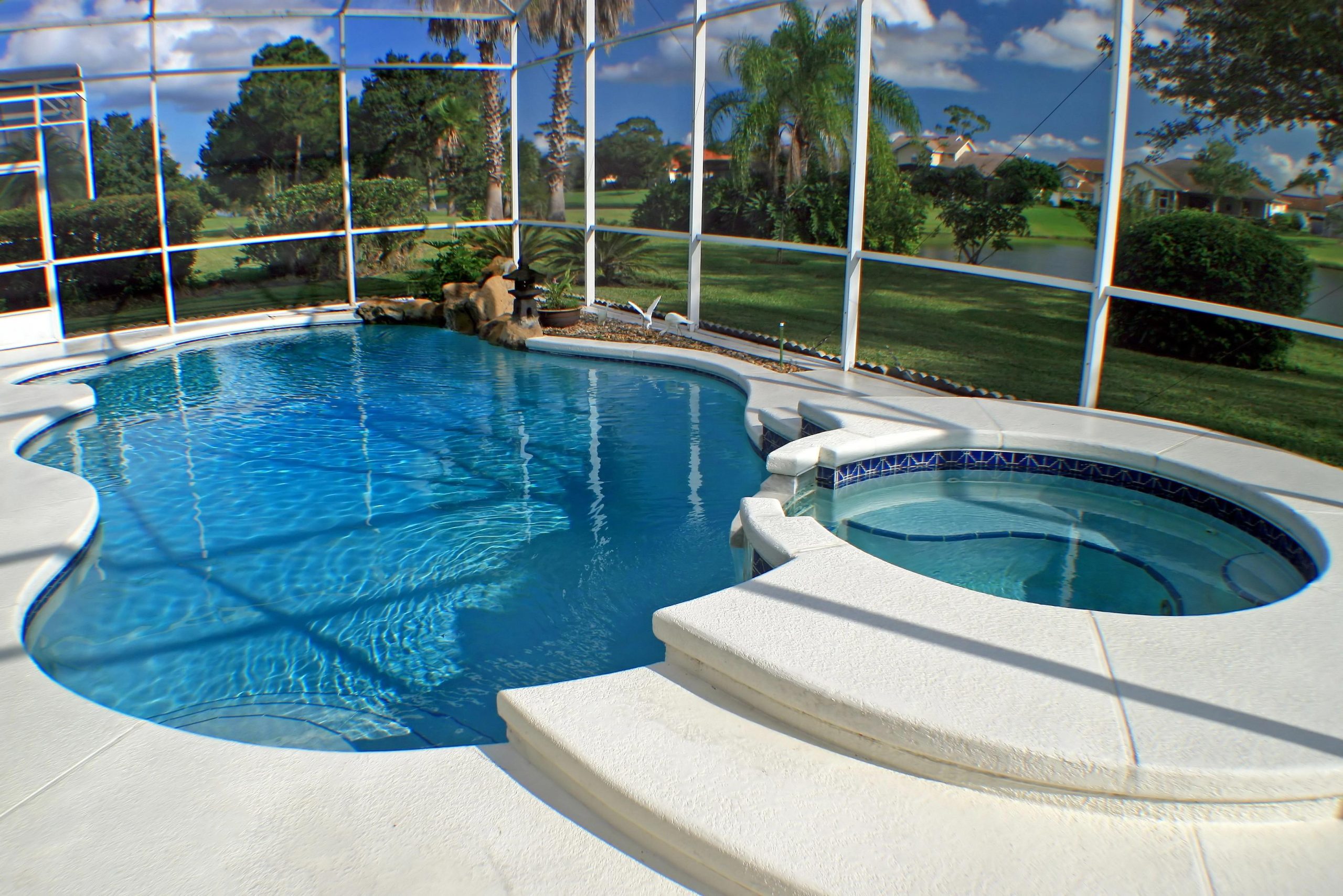 A swimming pool and spa with a lake view A swimming pool and spa with a lake view